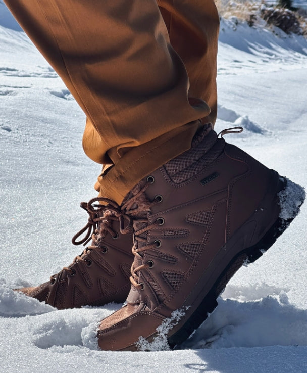Men black winter snow boots walking in snowy landscape, waterproof insulated boots for cold weather outdoor use